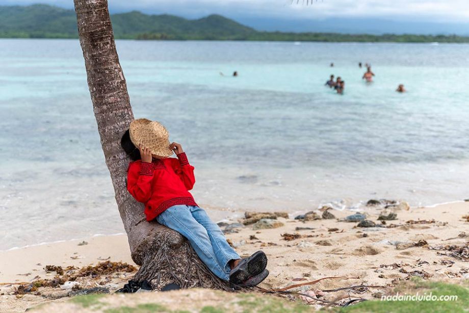 Niño guna apoyado en una palmera en isla Tigre (Digir dubbu) - Comunidad de la comarca Gunayala