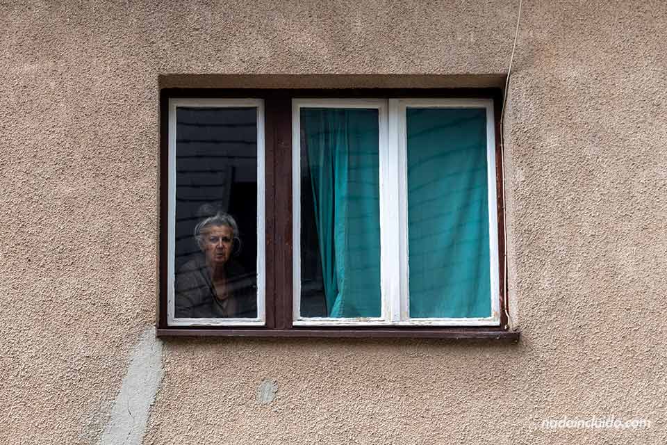 Señora asomada a una ventana junto al manantial del río Plava Voda en Travnik (Bosnia y Herzegovina)