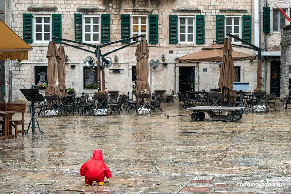 Niño jugando con la lluvia junto a la catedral de San Trifón en Kotor (Montenegro)