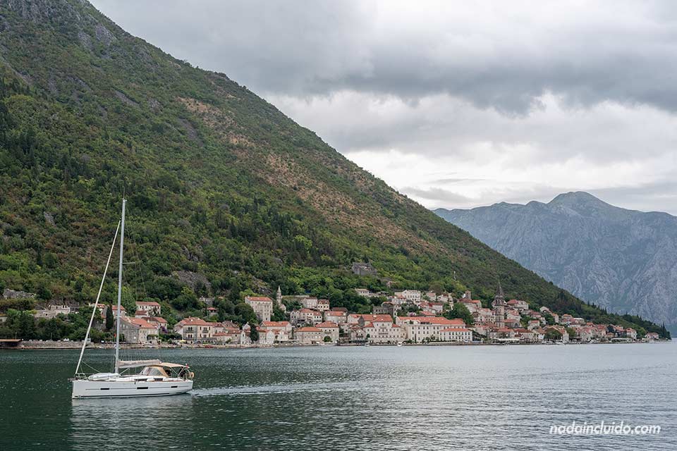 Un barco en la bahía de Kotor con Perast de fondo (Montenegro)