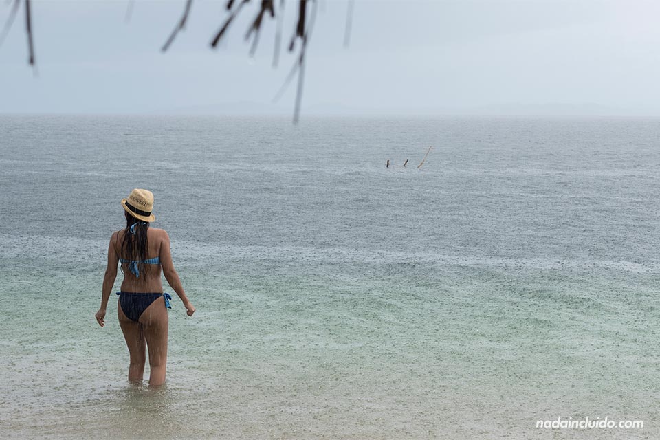 Una turista se baña bajo al lluvia en la playa de las Estrellas de Bocas del Toro (Panamá)