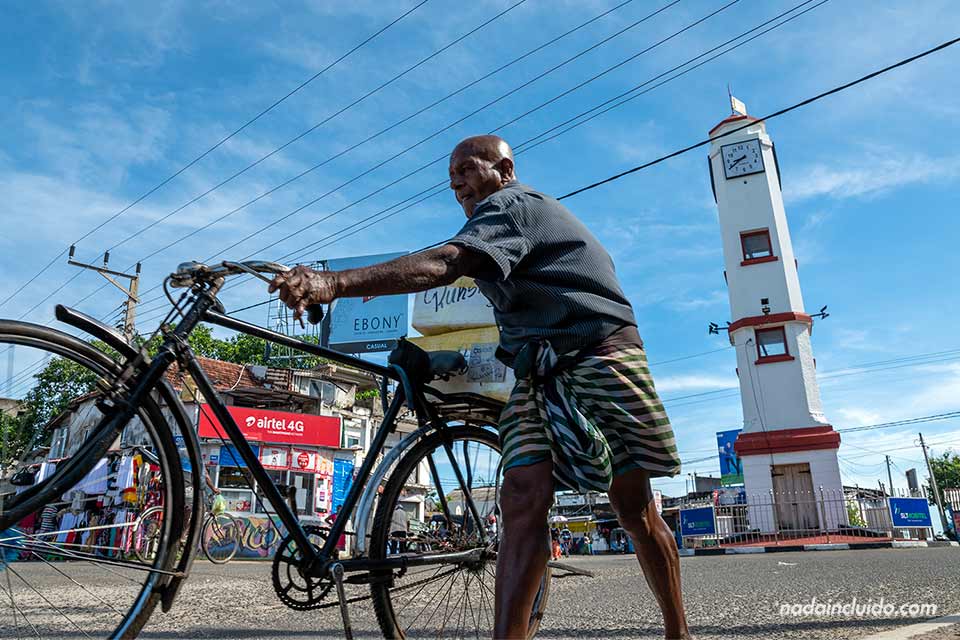 Hombre en bicicleta junto a la torre del Reloj de Trincomalee (Sri Lanka)