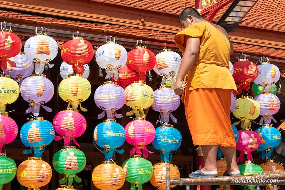 Monje coloca farolillos en el templo Wat Indharaviharn (Bangkok, Tailandia)