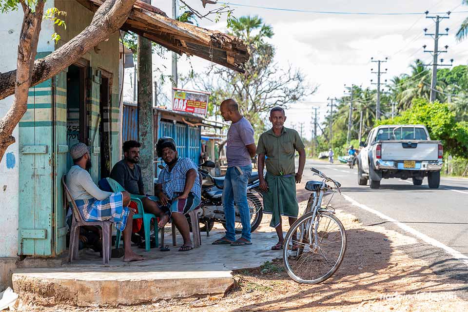 Esrilanqueses en la puerta de una tienda de pescado seco en Kinniya - Sri Lanka