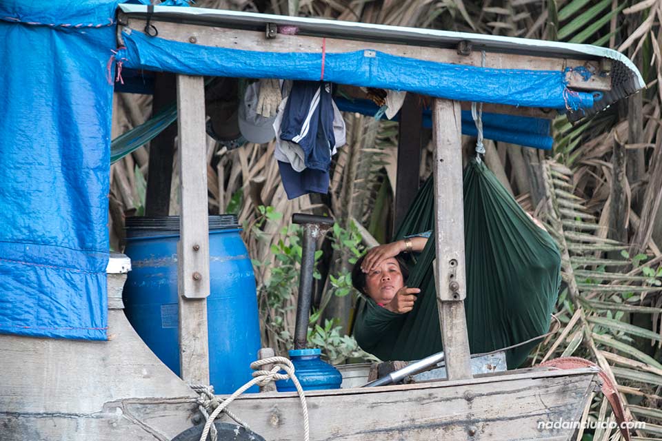 Mujer descansa en un barco vietnamita sobre el río Saigón (Vietnam)