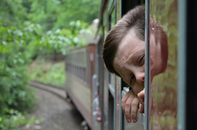 Un niño se entreasoma por la ventana de un tren rumbo a Polonia